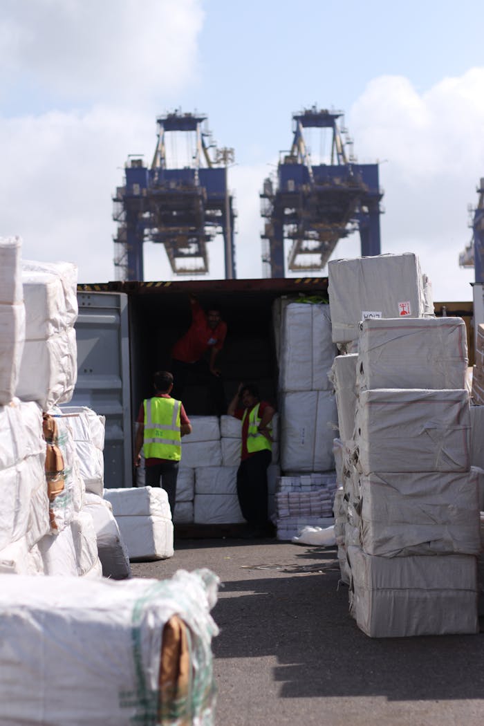 services-06 Dock workers loading cargo at Karachi Port with visible cranes and containers.